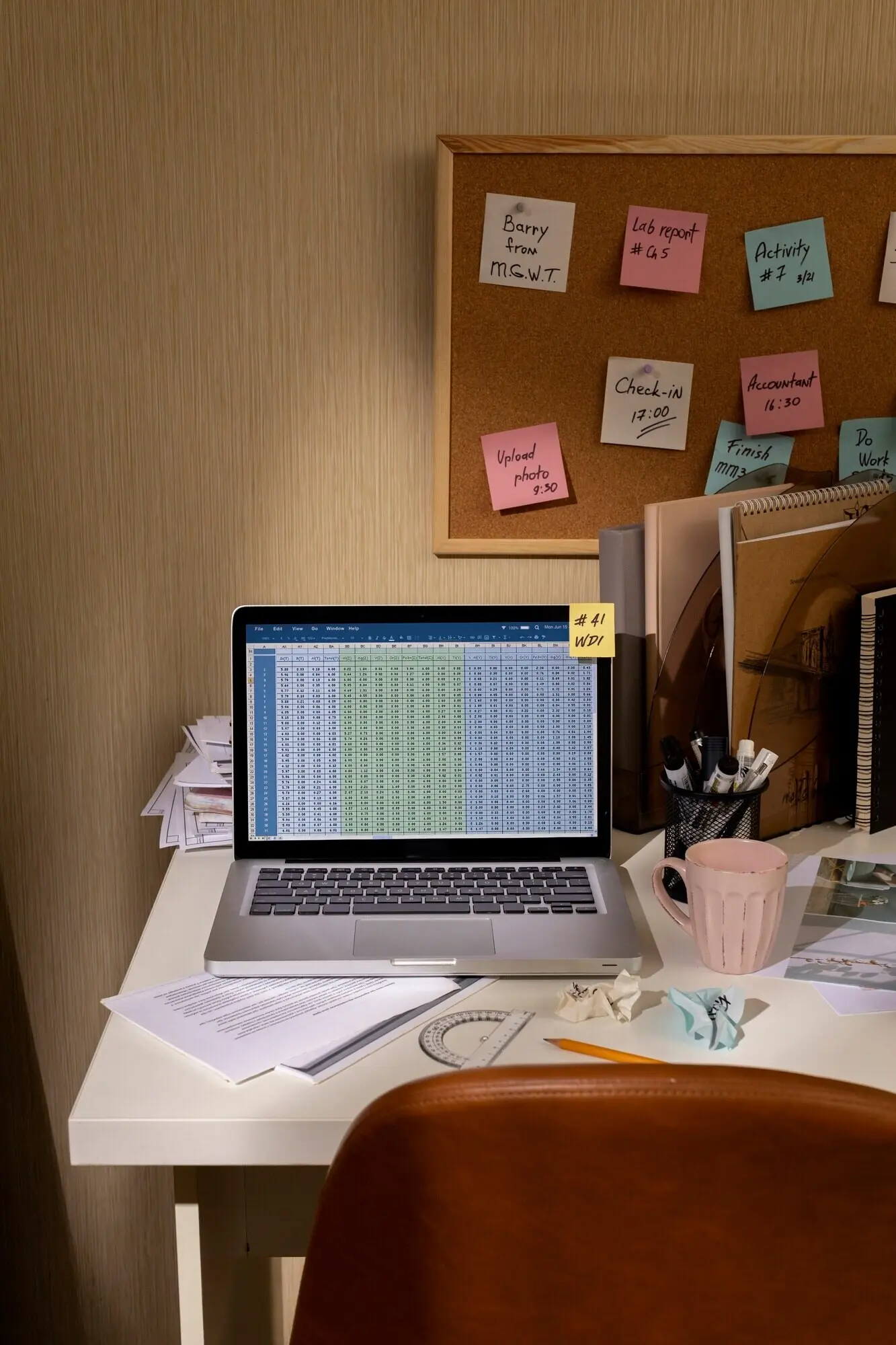 View of a cluttered office workspace with a laptop.